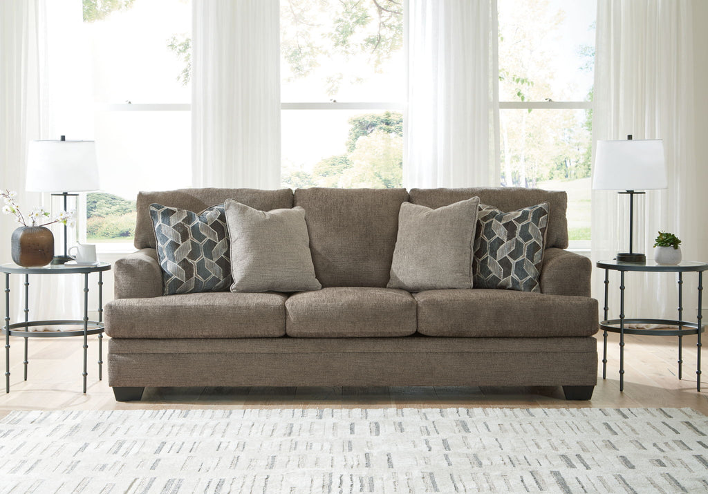 Upholstered sectional sofa with chaise in light brown, styled with geometric throw pillows