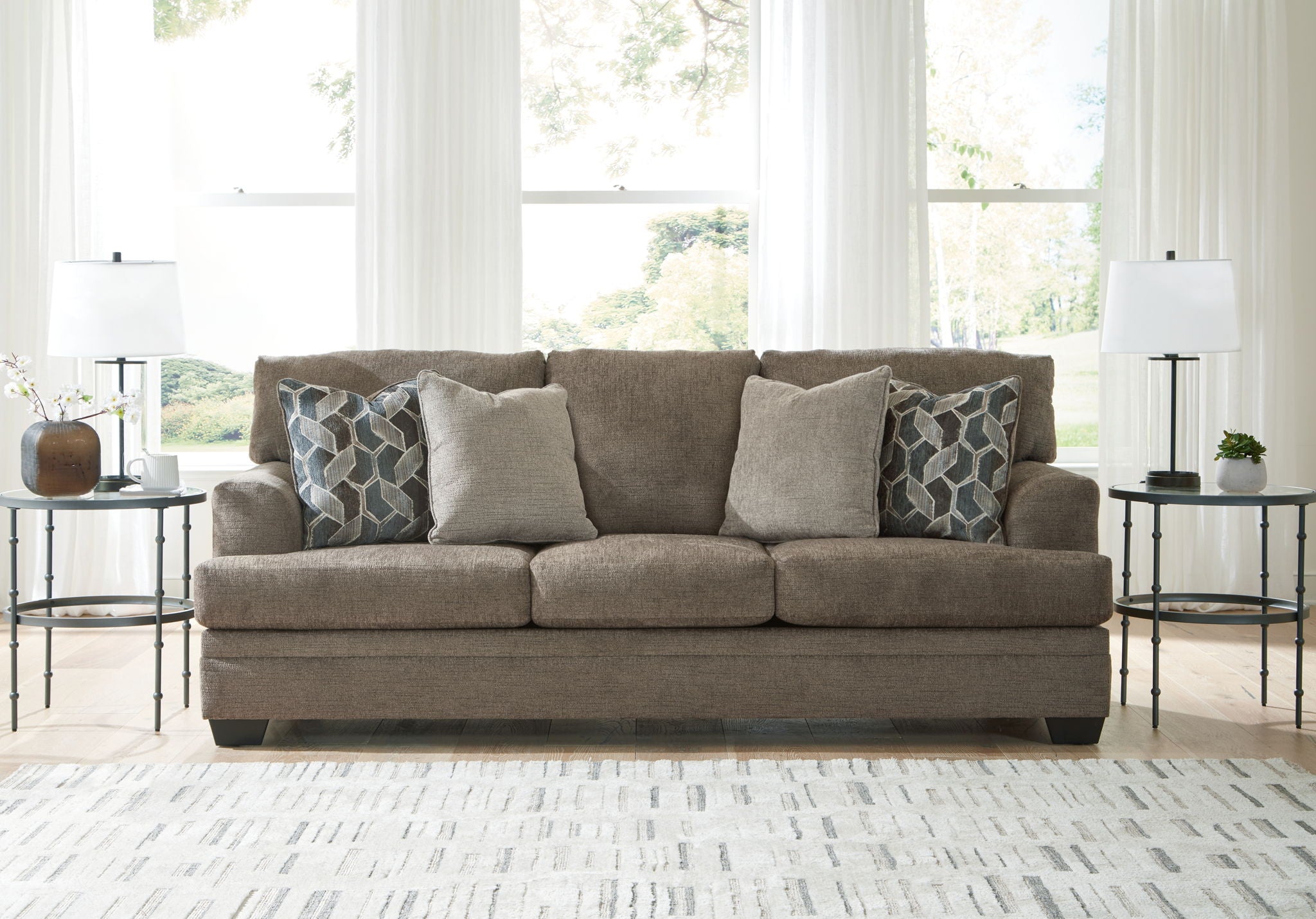 Upholstered sectional sofa with chaise in light brown, styled with geometric throw pillows