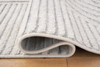 Light gray and white area rug with bound edge and ribbed pile detail