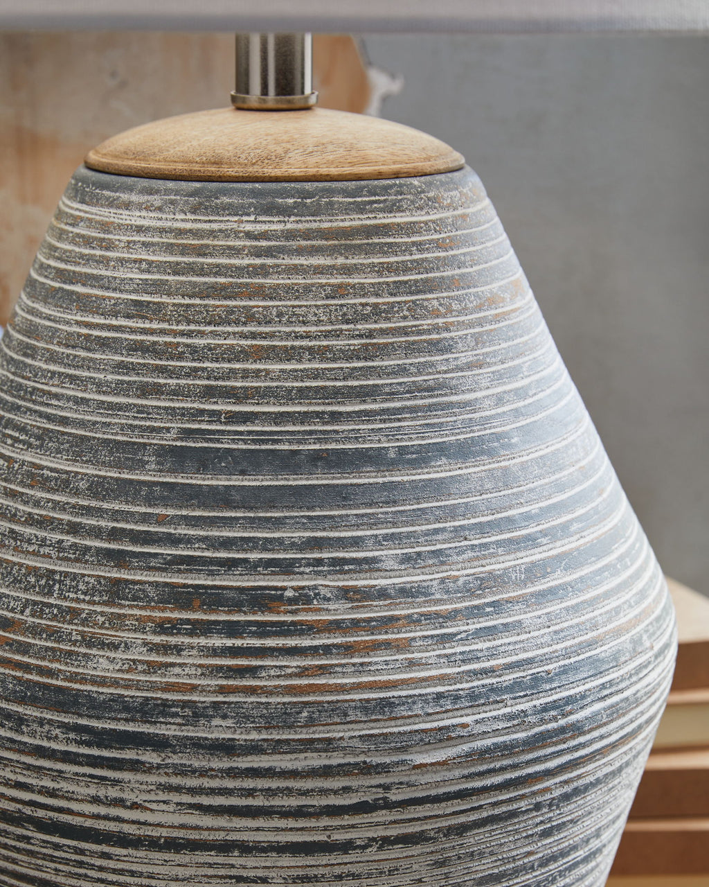 Table lamp base detail with blue-gray ribbed ceramic and dark speckles
