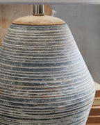 Table lamp base detail with blue-gray ribbed ceramic and dark speckles