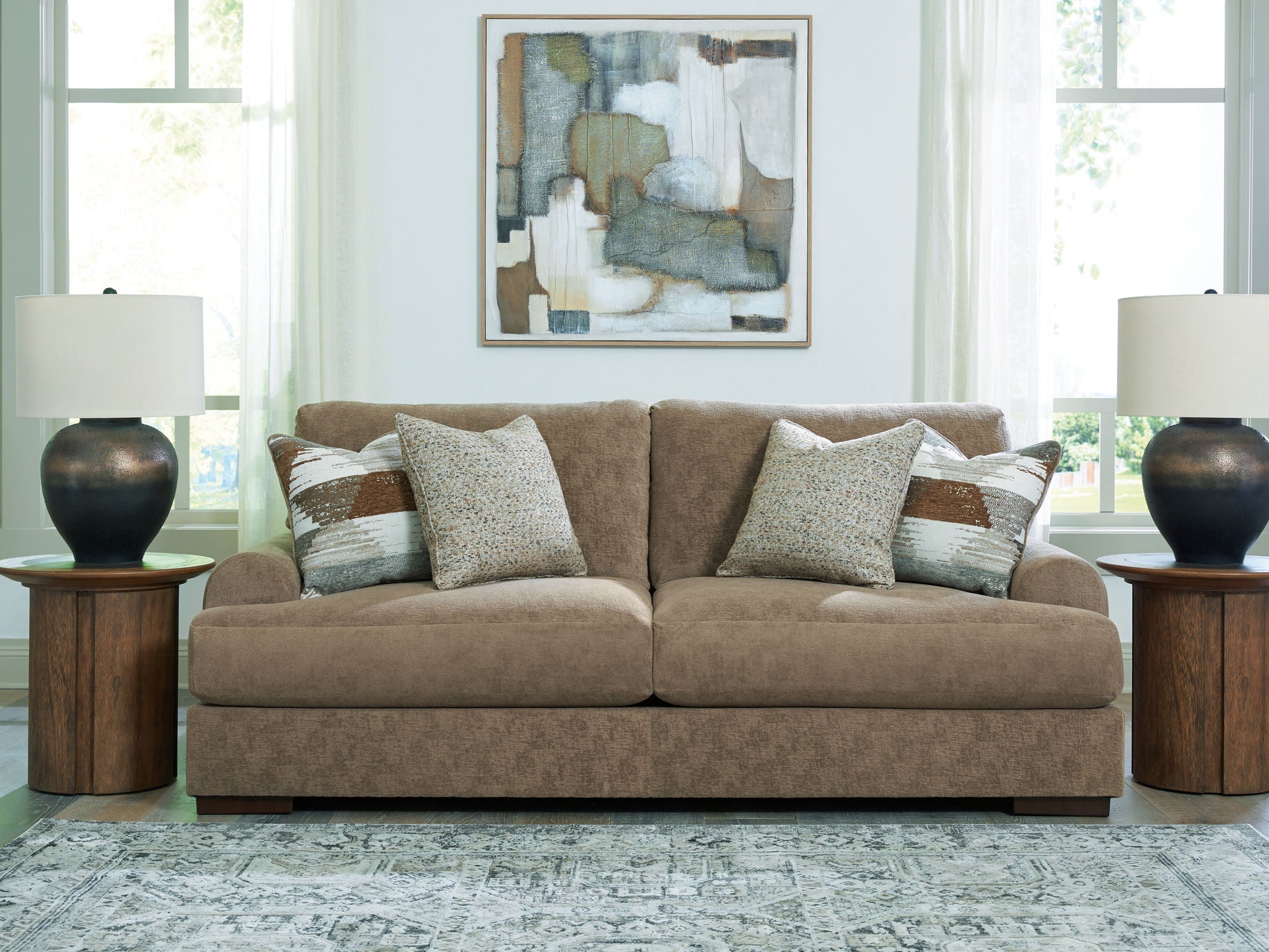 Taupe fabric sofa with three seat cushions and mixed-pattern throw pillows