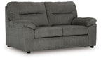 Dark gray fabric loveseat with rolled arms, two seat cushions, and tufted back
