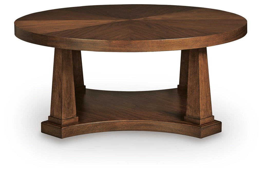 Round wooden coffee table with light brown top and thick pedestal support base