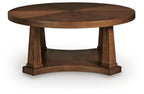 Round wooden coffee table with light brown top and thick pedestal support base