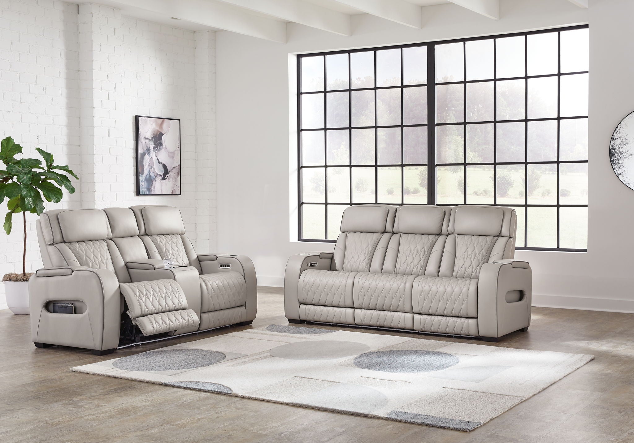 Gray reclining sofa and recliner set with quilted seats and padded armrest panels