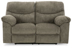 Reclining loveseat in dark gray fabric with rounded armrests and split seat