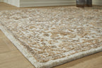 Light brown patterned area rug with dense, distressed floral motifs