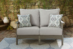 Gray outdoor loveseat with thick cushions and two diamond-pattern throw pillows