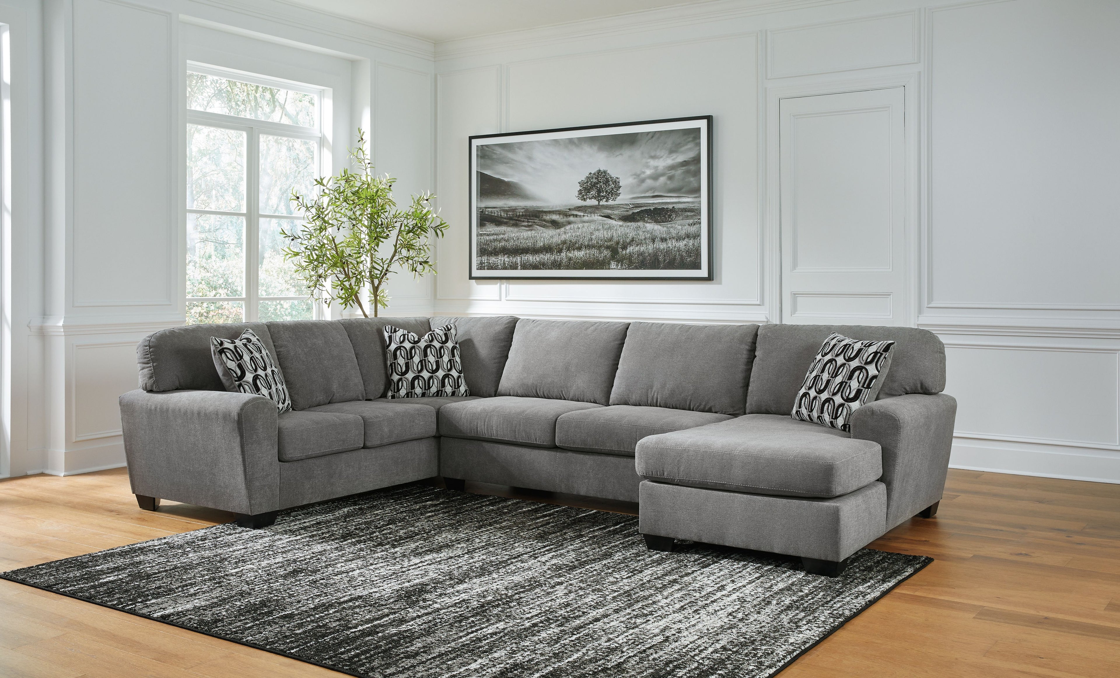 Gray sectional sofa with corner chaise and patterned pillows, wide seat and chaise cushions