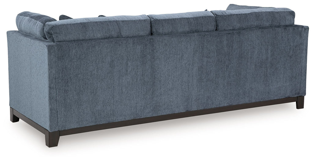 Navy fabric sofa with tufted arms and dark wooden legs