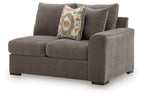 Gray fabric right-arm loveseat with two throw pillows and dark wooden legs.