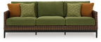 Three-seat wicker sofa with green cushions, patterned green pillows, and brown accent pillows
