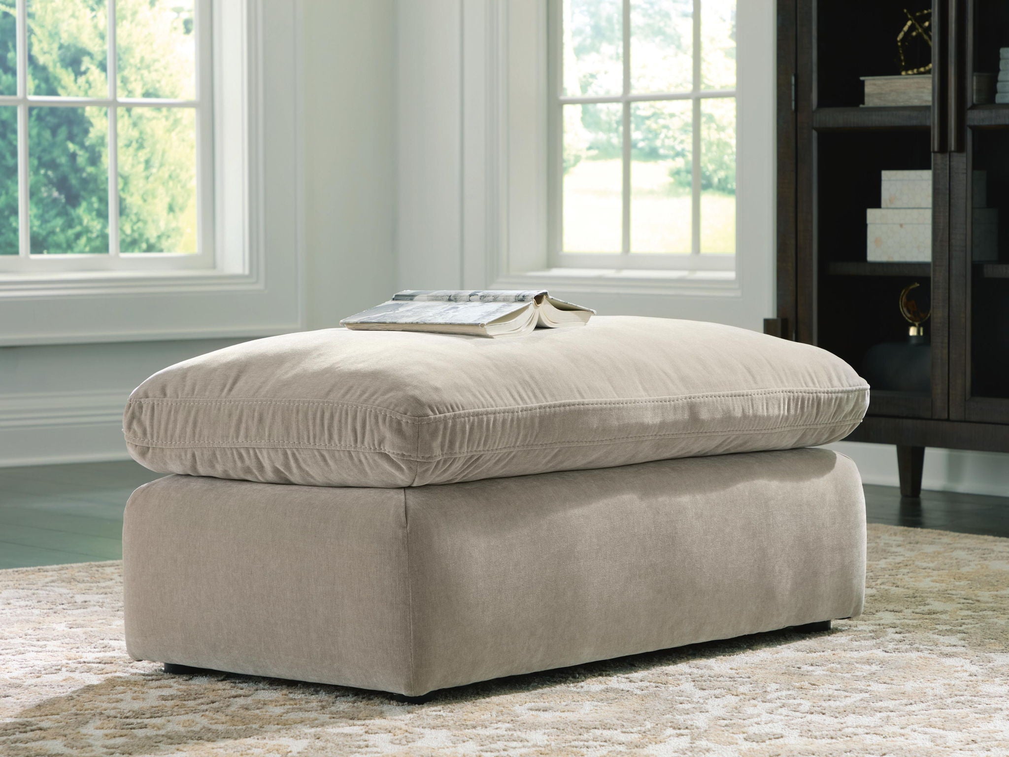 Light gray upholstered ottoman with stacked seat cushion and short legs