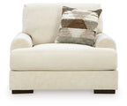 Armchair in beige fabric with thick seat and back, and a brown-and-white patterned throw pillow