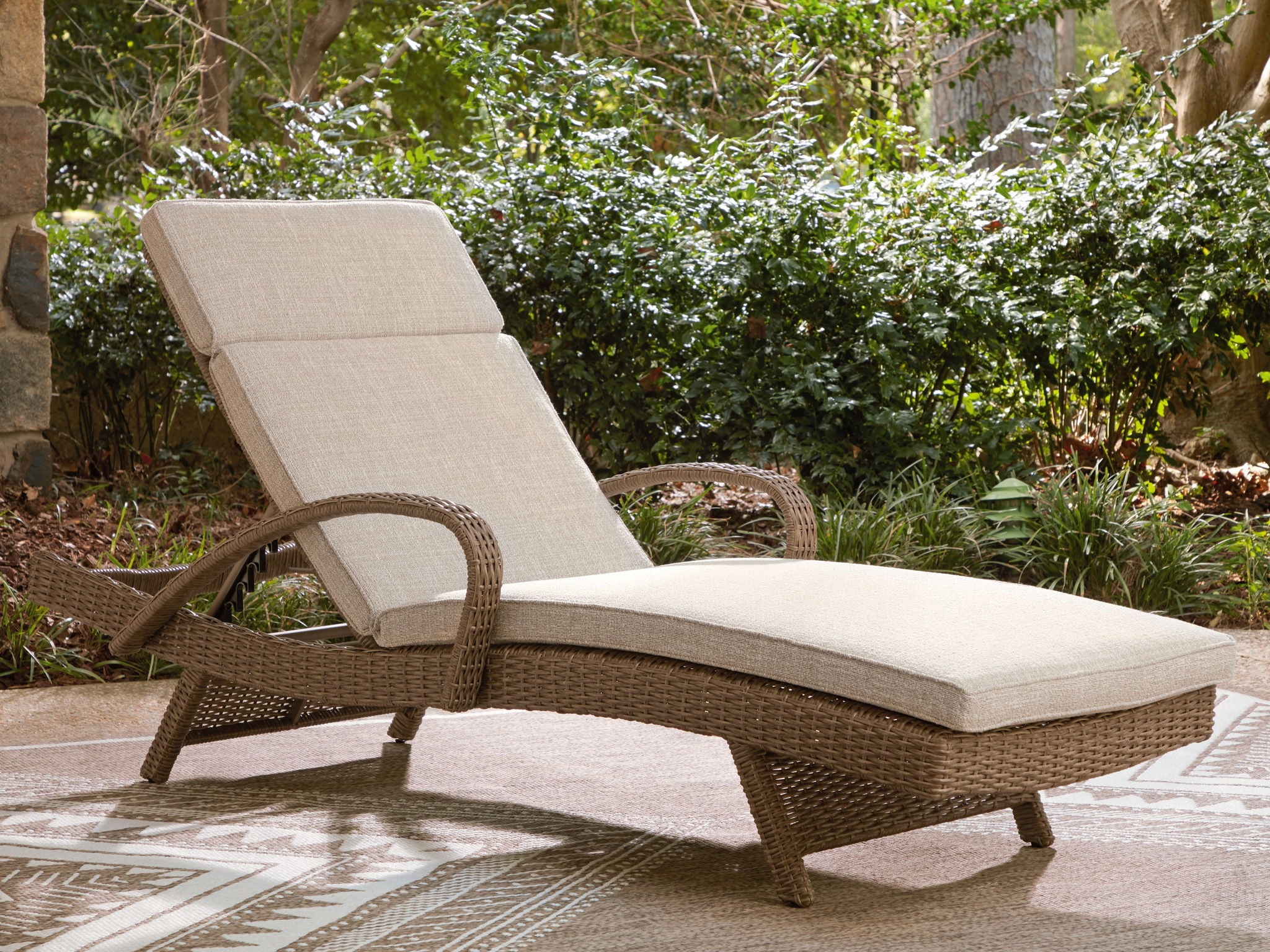 Beige chaise lounge with cushion, woven brown frame and tall back panel