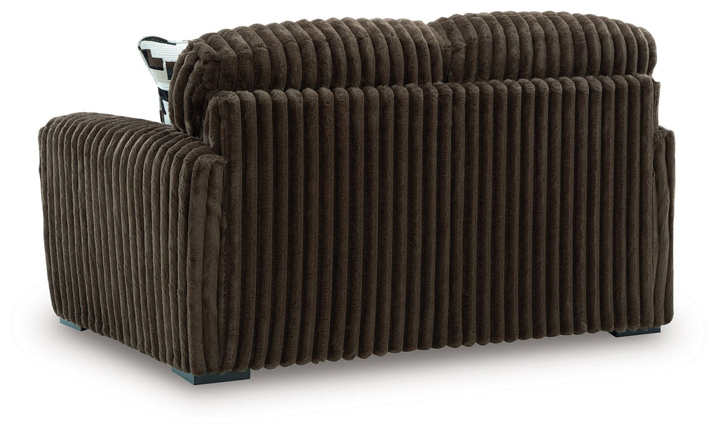 Dark brown corduroy loveseat with rounded arms and vertical channel stitching