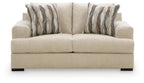 Beige loveseat with tufted back cushions and two striped throw pillows