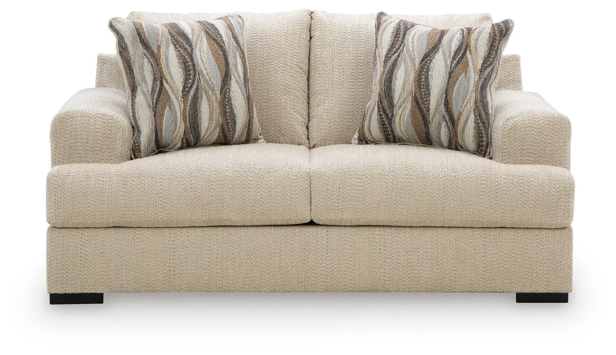 Oatmeal upholstered loveseat with two striped throw pillows
