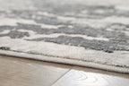 Gray abstract rug border edge with stitched fringe and low-pile texture