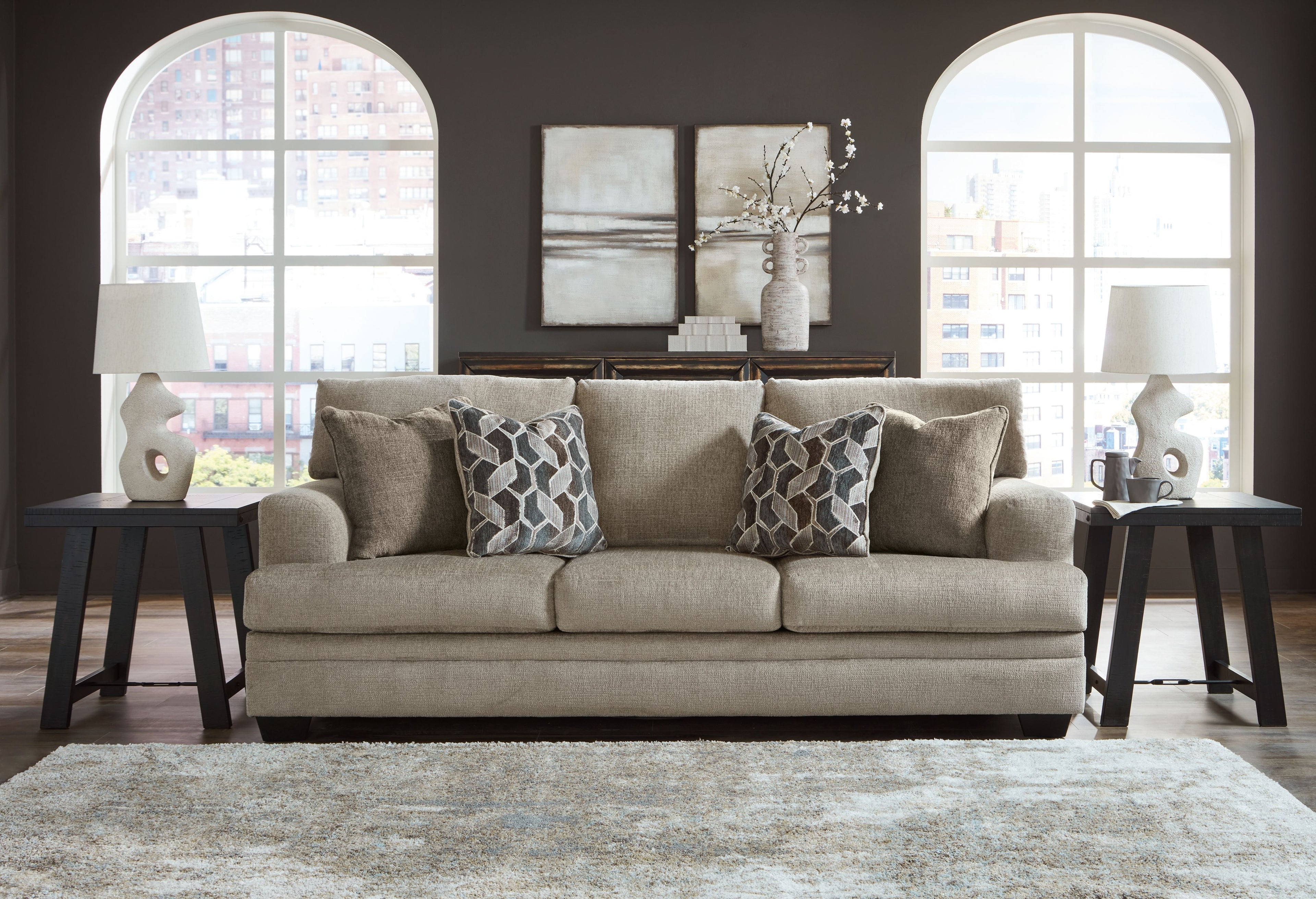 Stonemeade sofa in light taupe with four accent pillows and two geometric patterned cushions
