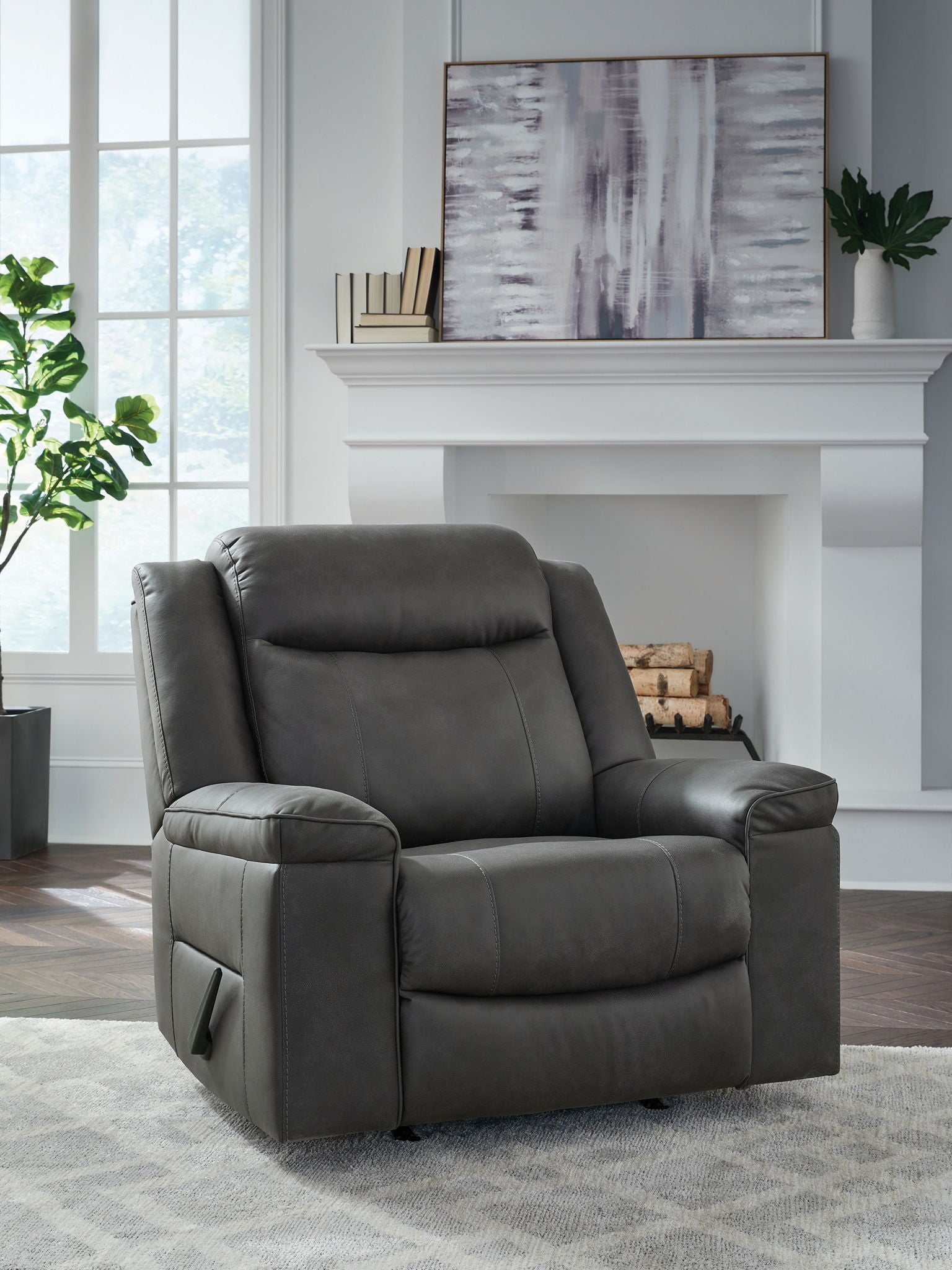 Dark gray rocker recliner chair with tall backrest, stitched seat, and padded armrests.