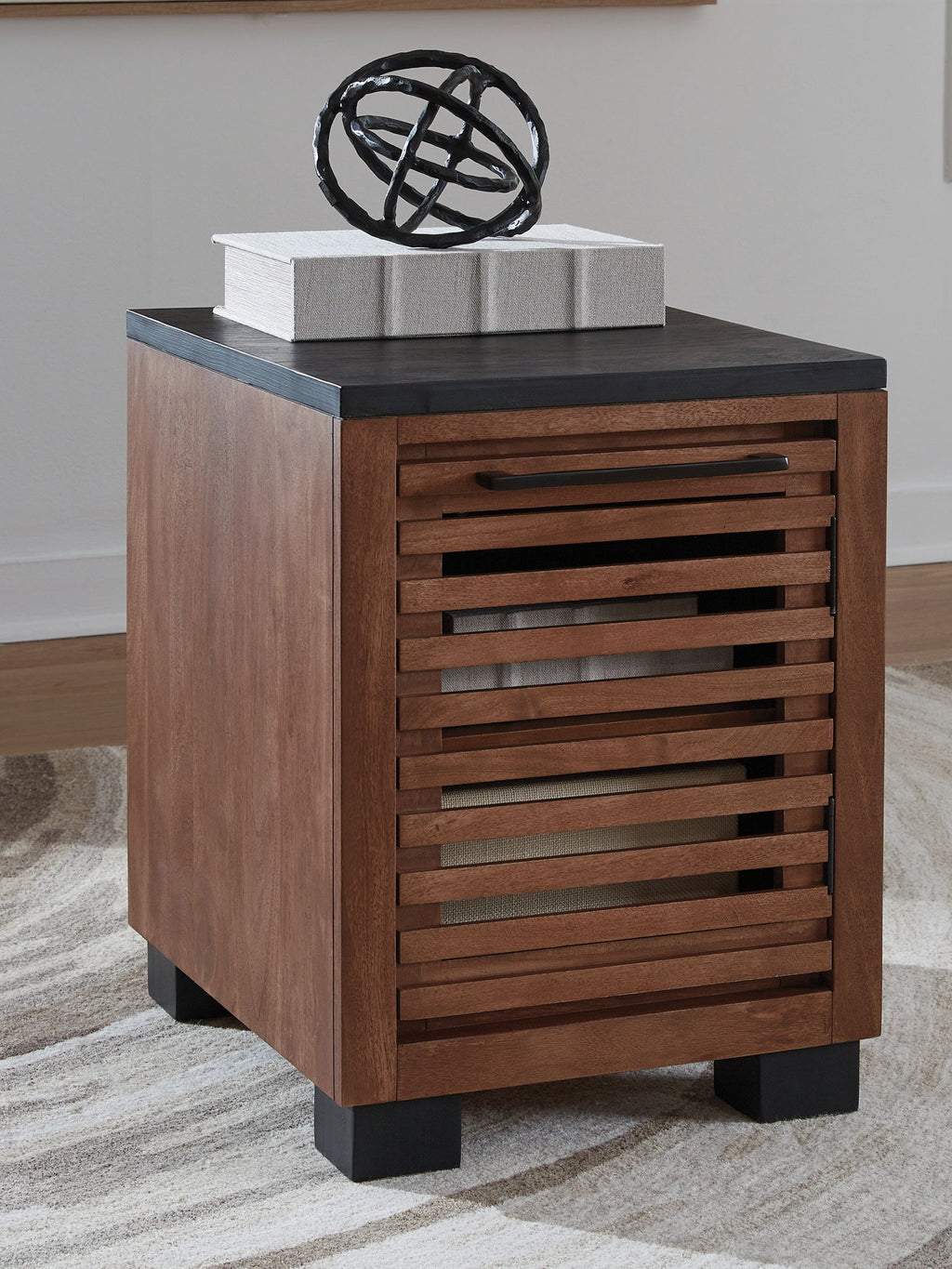 Warm brown chair side end table with black top and slatted drawer front