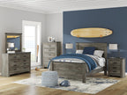 Gray bedroom mirror with white frame, leaning on a dresser with drawers