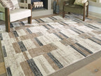 Beige abstract block-pattern area rug with dark gray bands and tan highlights