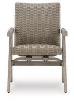 Rocking arm chair with woven beige back and seat, light wood arms and legs