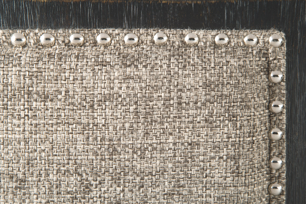 Bench seat with textured light upholstery and silver nailhead trim along the border
