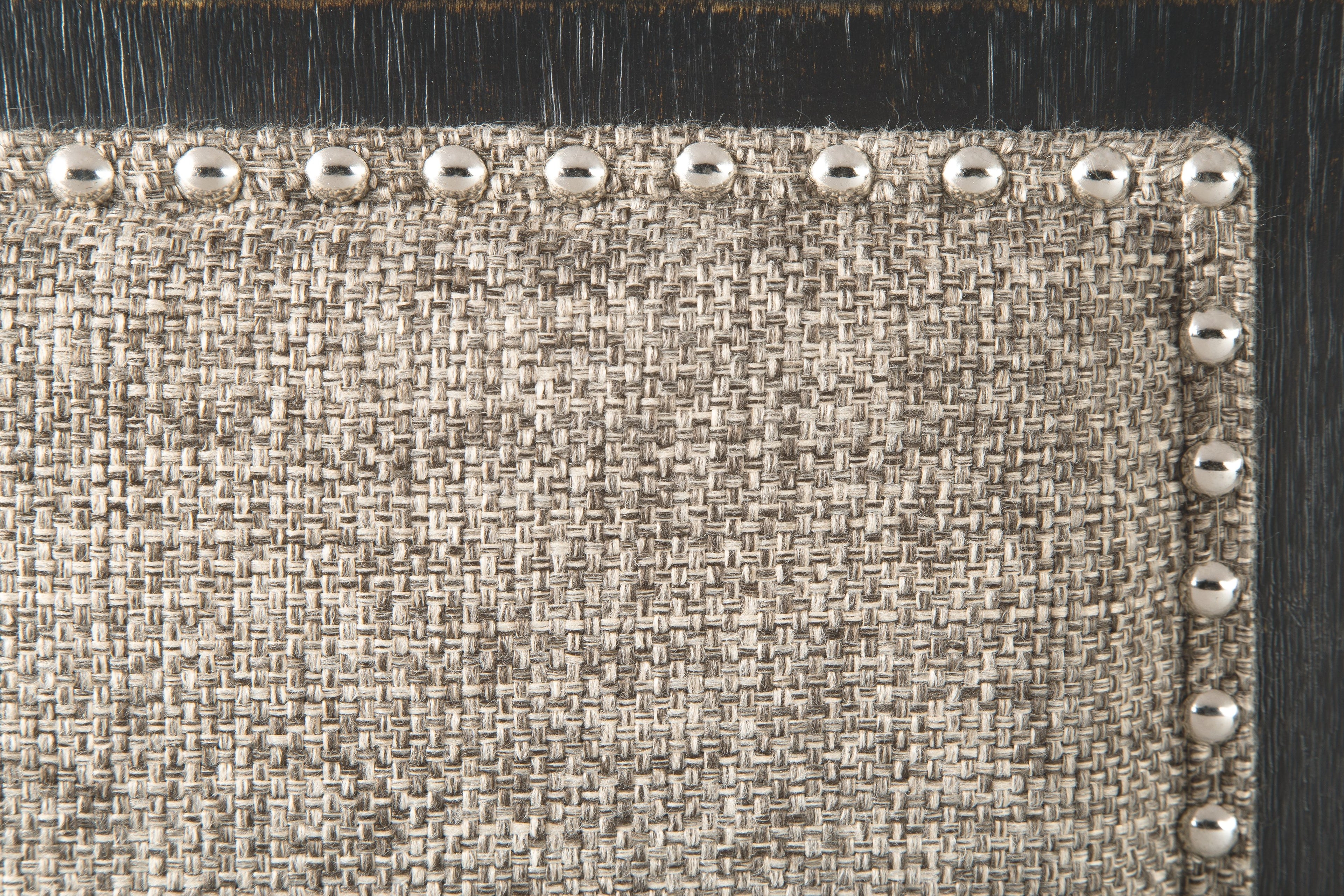 Bench seat with textured light upholstery and silver nailhead trim along the border