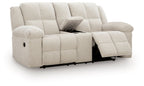 Reclining loveseat with extendable footrests and console, light beige cushioned frame