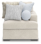 Fabric corner chair with textured light gray upholstery, block feet, and plush lumbar pillows