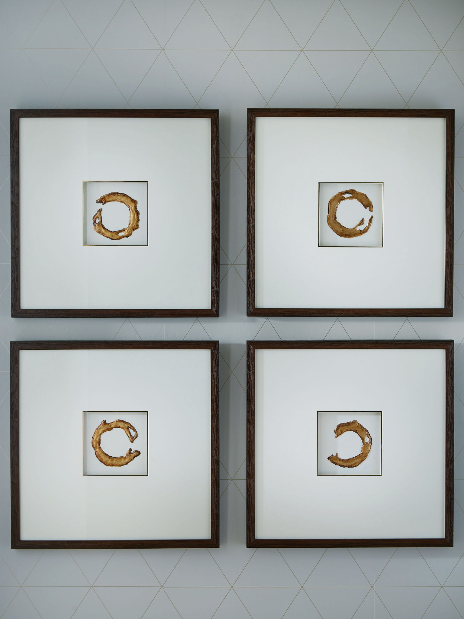 Set of 4 framed wall art prints with white backgrounds and gold abstract circular shapes