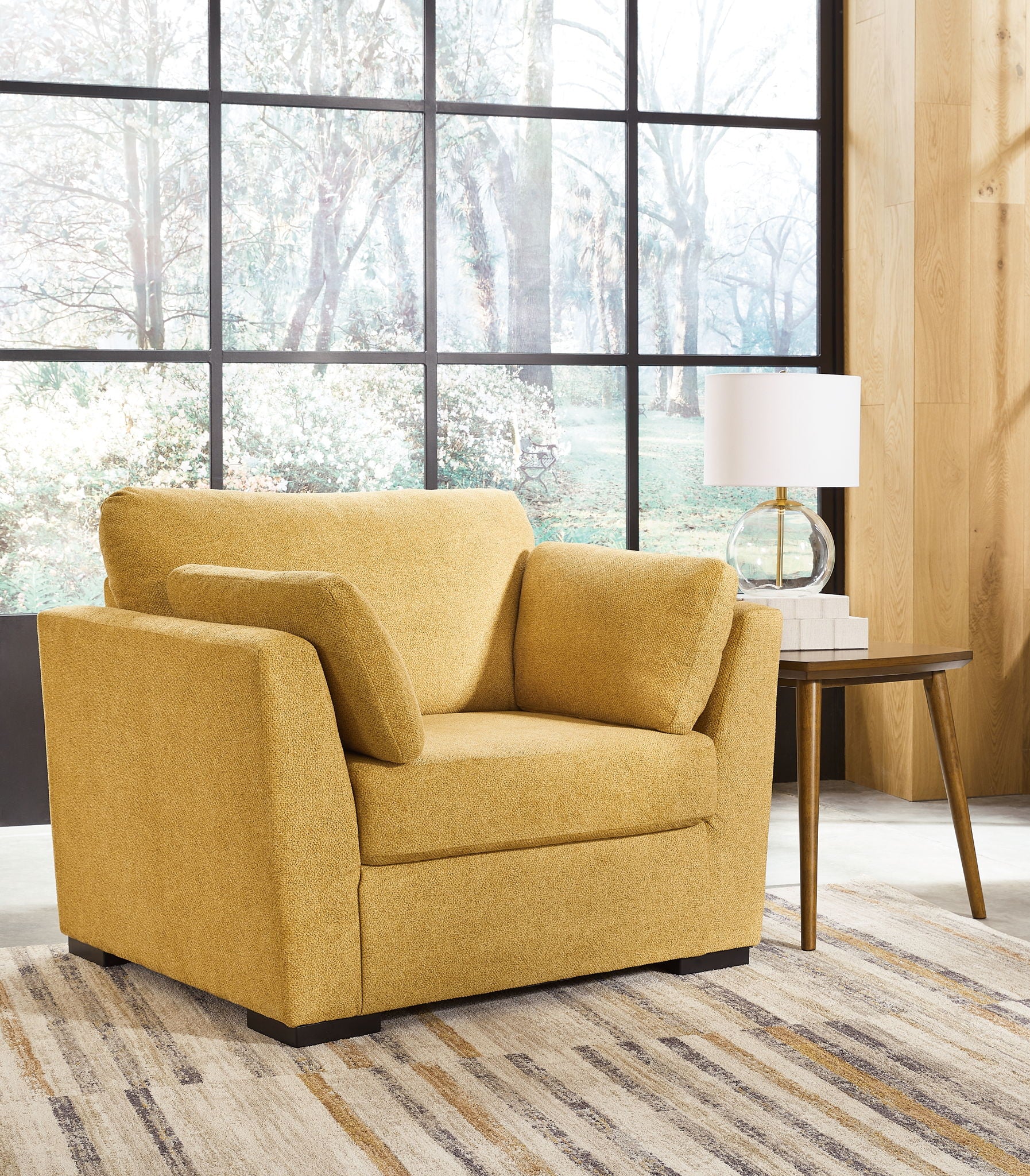 Yellow upholstered armchair with wide arms and tufted back cushion