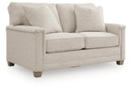Light beige upholstered loveseat with rolled arms, three back cushions, two seat cushions