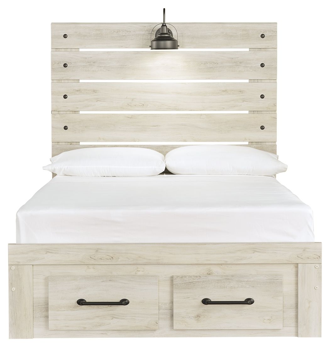 Light wood panel bed with two front drawers; white bedding and two black bedside lamps on headboard