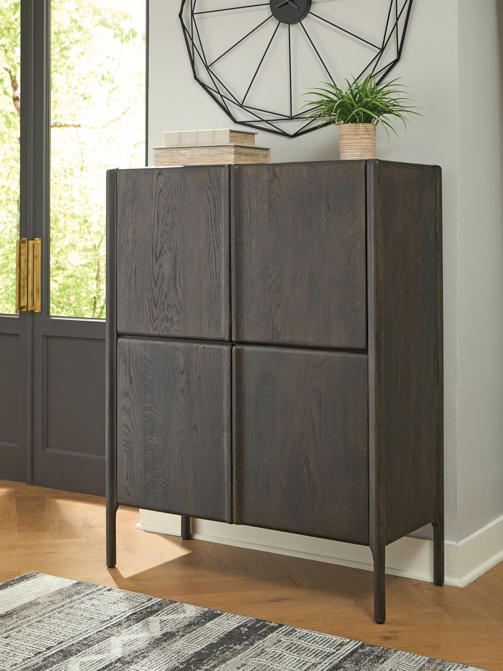 Dark espresso brown accent cabinet with four panel doors and tapered metal legs