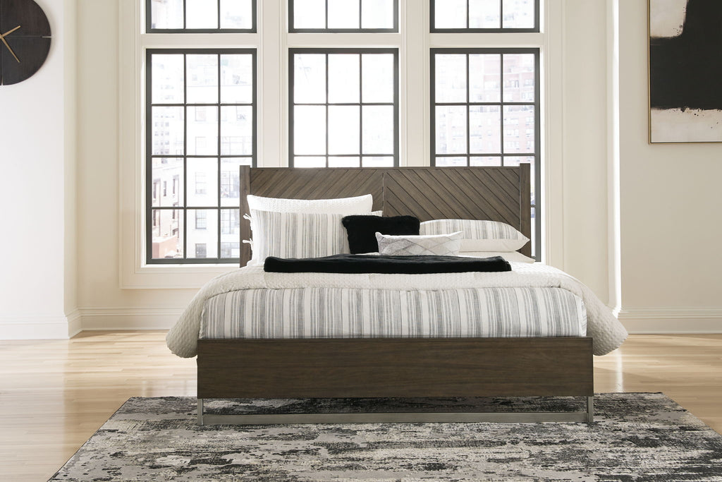 Grayish-brown panel bed with white-and-gray striped bedding and pillows