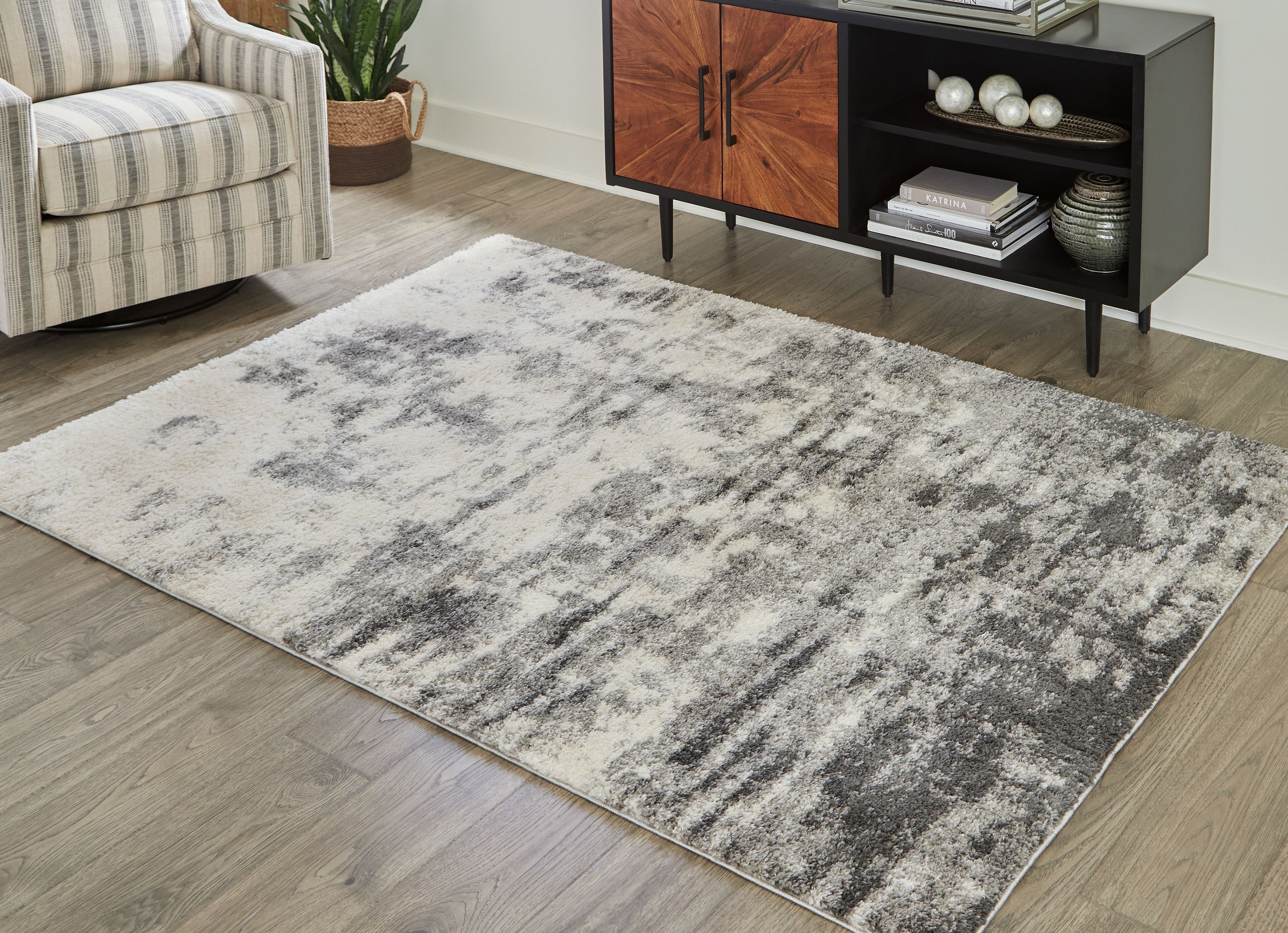 Pearl silver abstract area rug with distressed, mottled pattern and plush shag pile