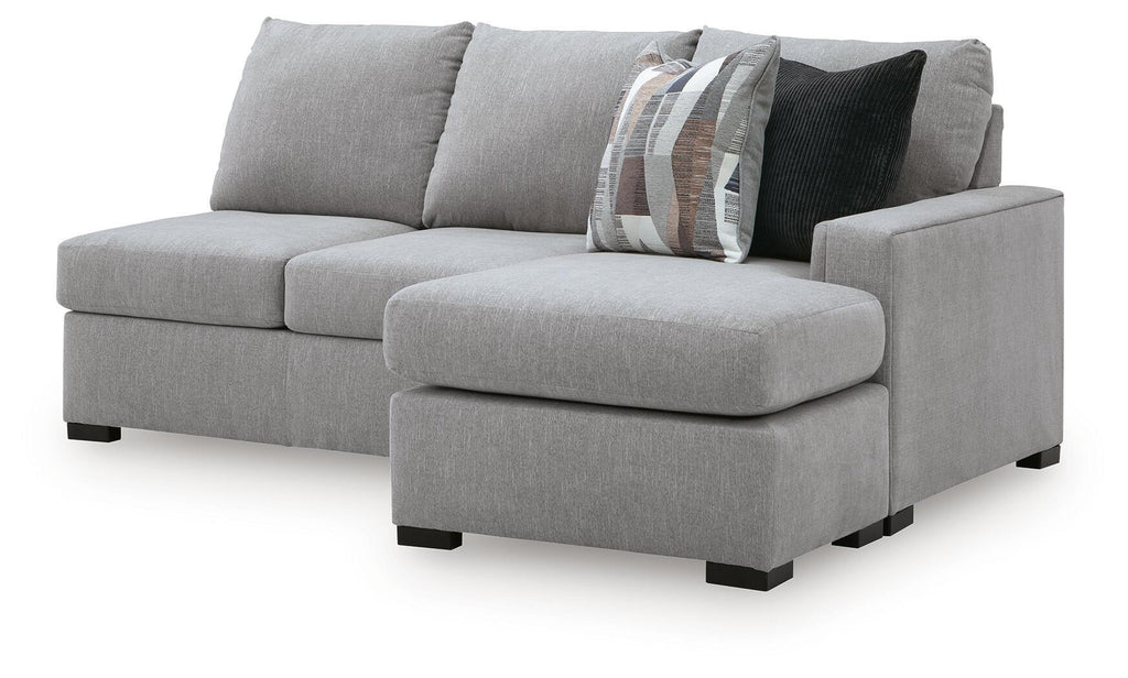 Light gray sofa chaise sectional with single chaise ottoman, curved arms, and patterned pillows