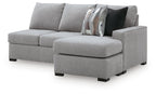 Light gray sofa chaise sectional with single chaise ottoman, curved arms, and patterned pillows