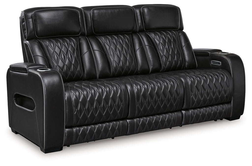 Black power reclining sofa with quilted leather-look upholstery and padded armrest