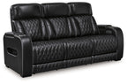 Black power reclining sofa with quilted leather-look upholstery and padded armrest