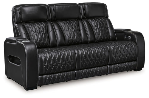 Black power reclining sofa with quilted leather-look upholstery and padded armrest