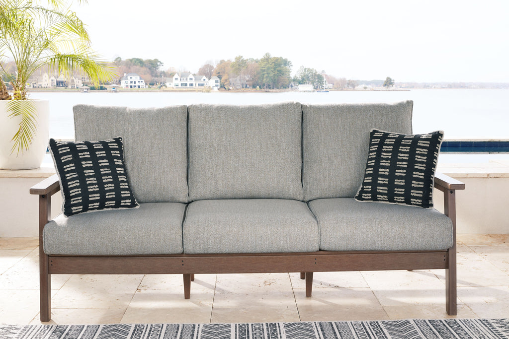 Grey upholstered sofa with two black-and-white patterned throw cushions