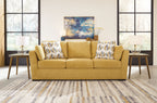 Keerwick sofa in sunflower yellow with patterned pillows, plush three-cushion seat