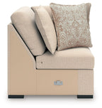 Light beige wedge chair with gray throw pillows and patterned accent pillow
