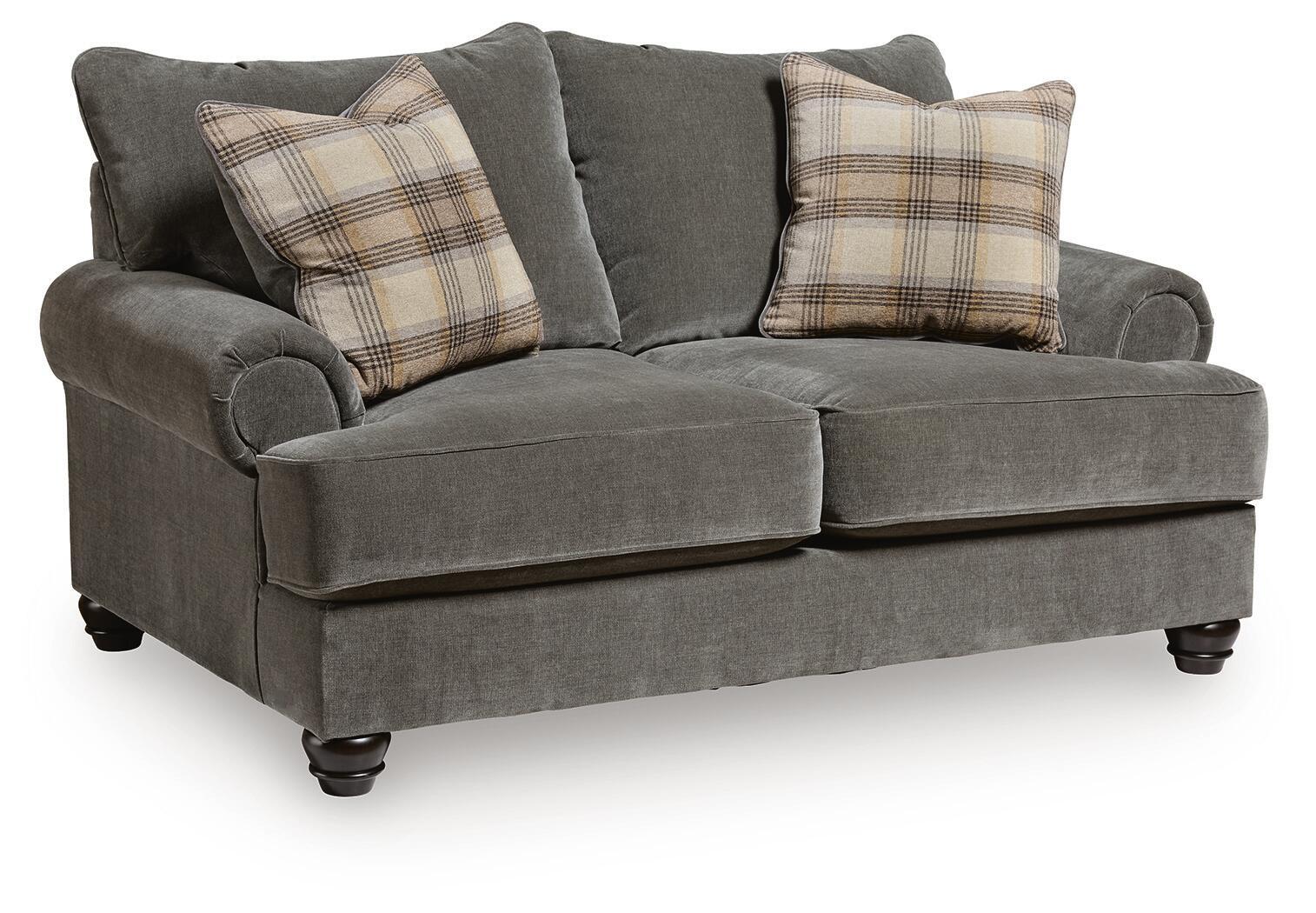 Gray upholstered loveseat with tufted arms and two plaid throw pillows